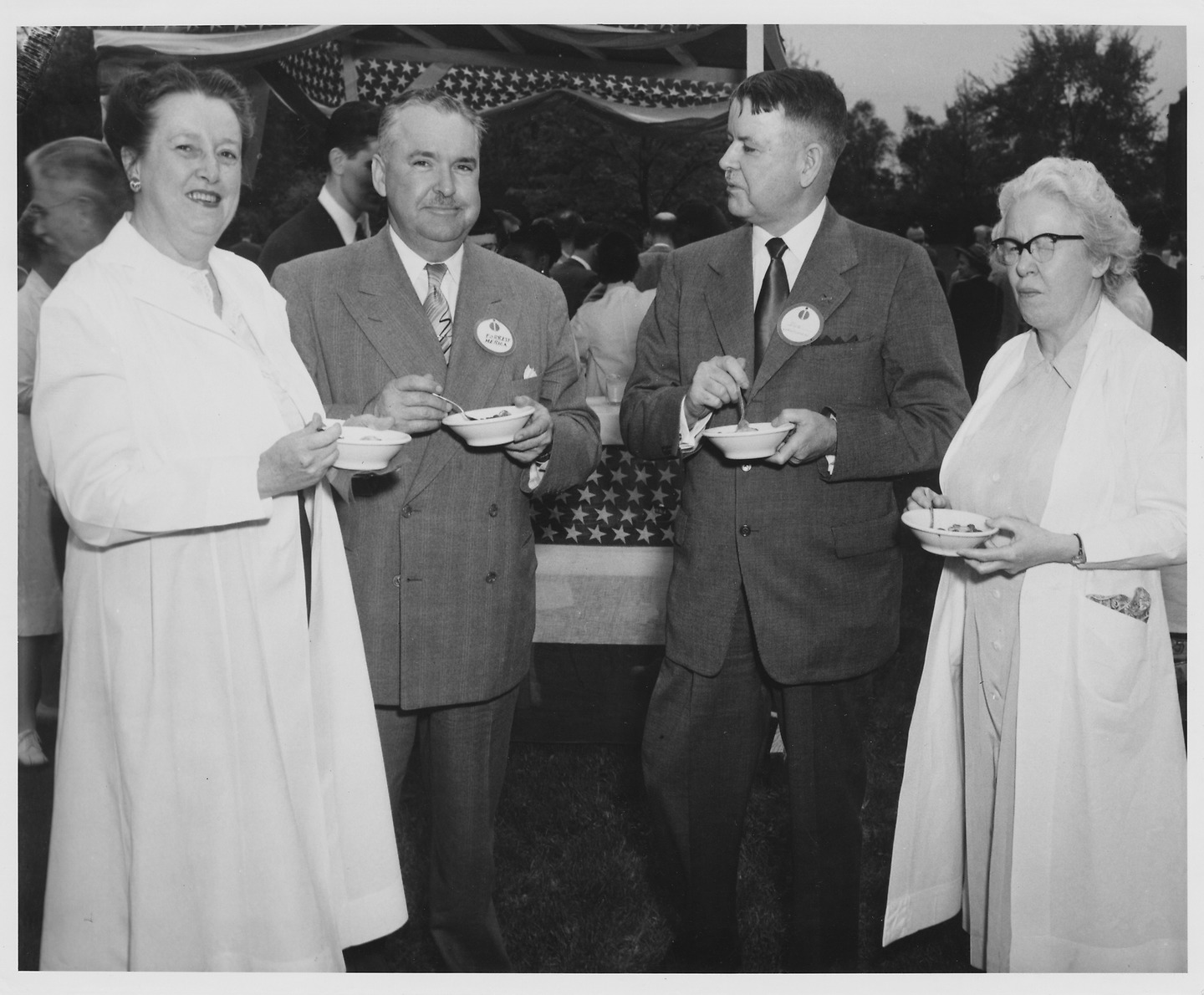 four alumni share strawberry shortcake outside in a historic black and white photo