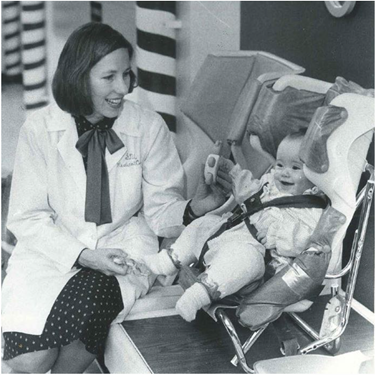 Marilyn Bull in her early career with infant in car seat