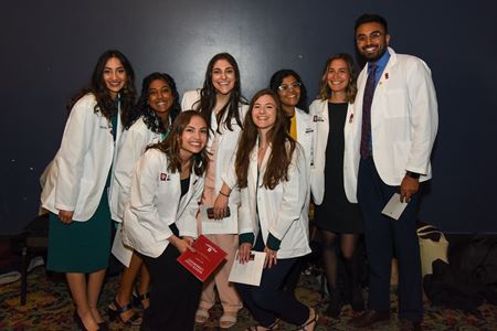 Medical students in white coats at the Murat Theatre