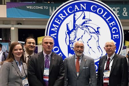 Richard Kovacs with colleagues in front of a American College of Cardiology sign