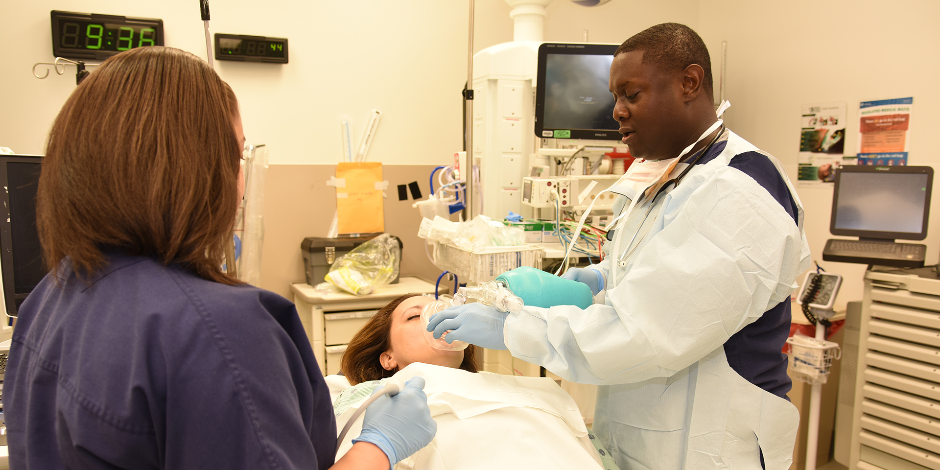 Dr. Musey in the emergency department in the presence of a learner providing care to  a patient. 