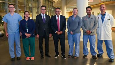 a group of faculty in a mix of scrubs and suits