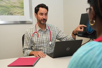 Jared Brosch, MD, associate professor of clinical neurology, meets with a clinical trial participant.