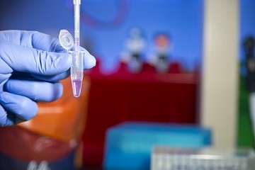 colorful image of a hand holding a test tube in a lab