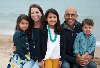 Dr. Karl Bilimoria is pictured at the beach with his wife, Sheila, and three children, in casual clothing. 