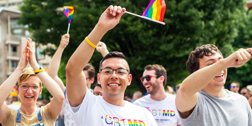 a student waves a rainbow flag at the pride parade in 2019