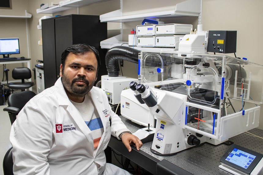 Kanhaiya Singh sits in front of a microscopy instrument